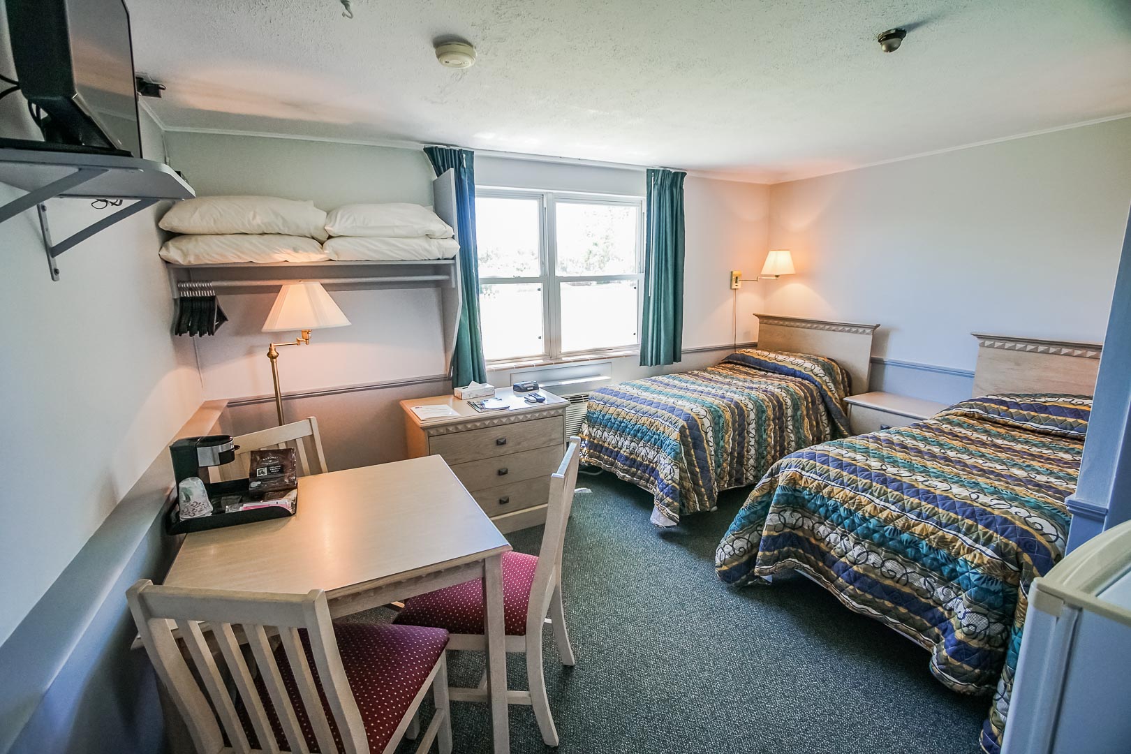 A cozy bedroom with double beds at VRI's Harbor Landing Resort in Massachusetts.